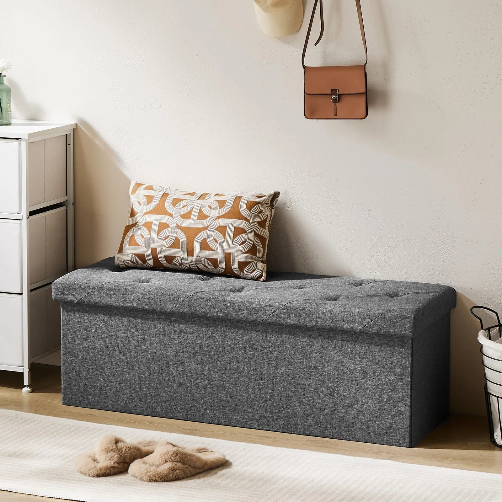 The folding storage ottoman at the foot of the bed.
